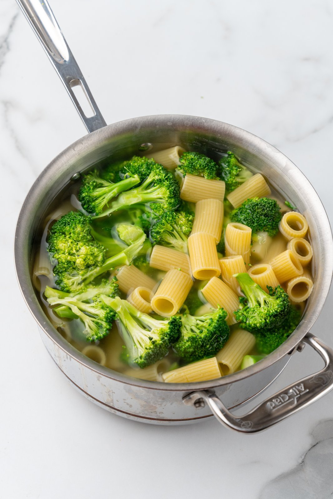a pot with broccoli and noodles