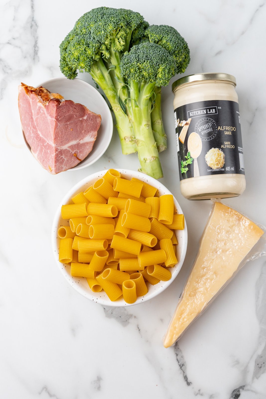 a top down photo of the ingredients needed to make ham broccoli alfredo