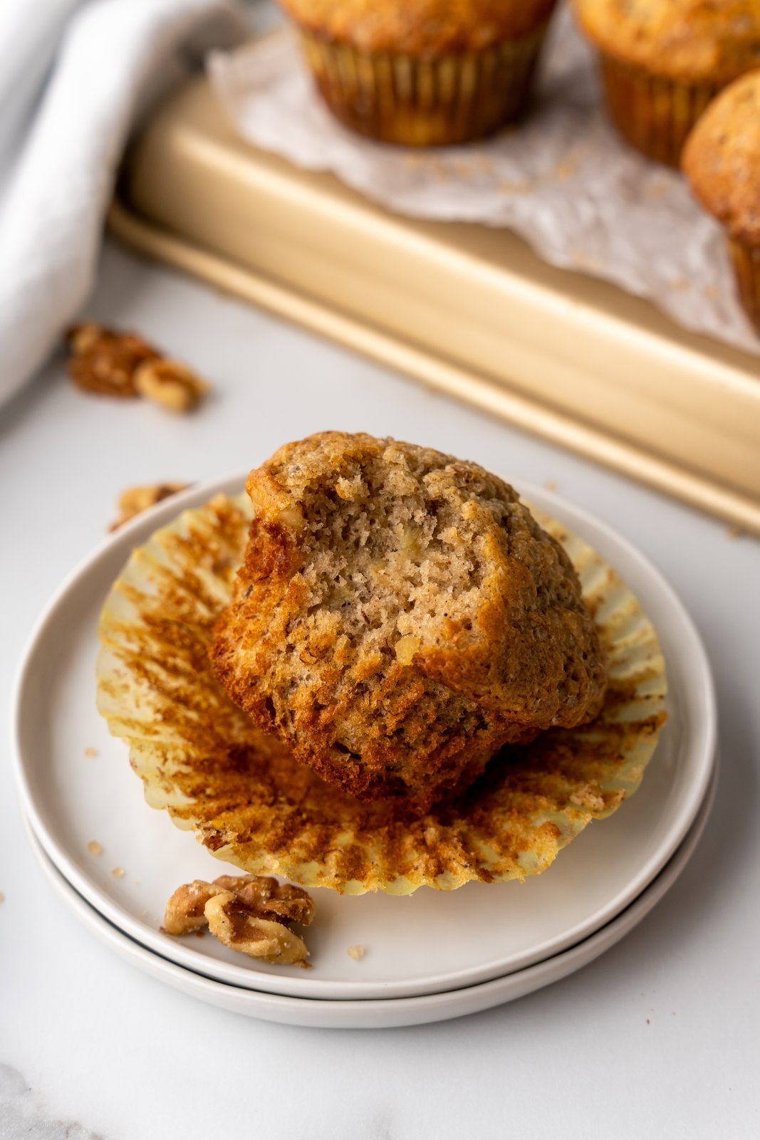 banana walnut muffin on a plate with a bite taken out
