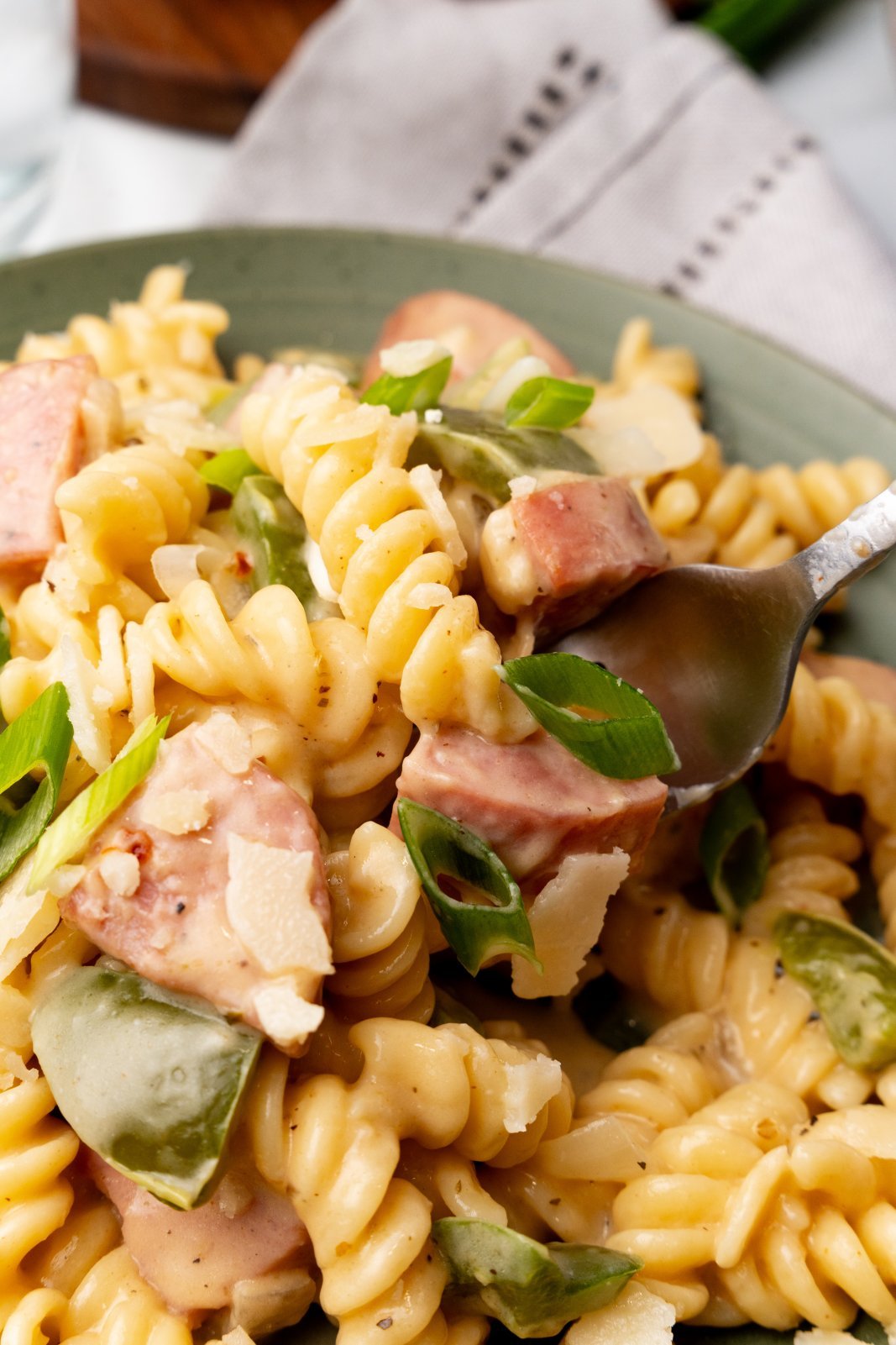Close up of kielbasa cheesy pasta on a fork