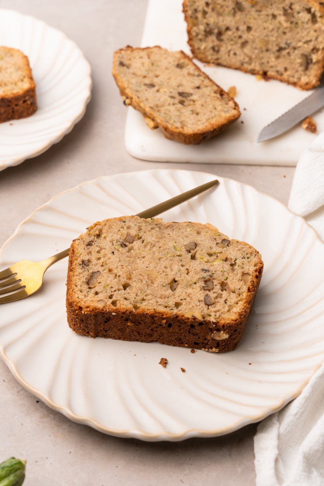 a slice of zucchini bread on a plate with a fork