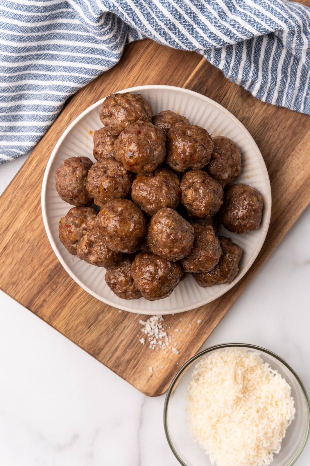a top down view of a plate of cooked meatballs on a wooden board