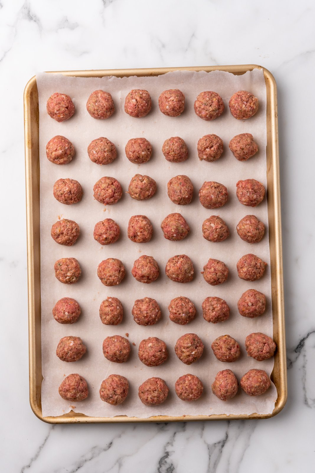 raw meatballs on a sheet pan
