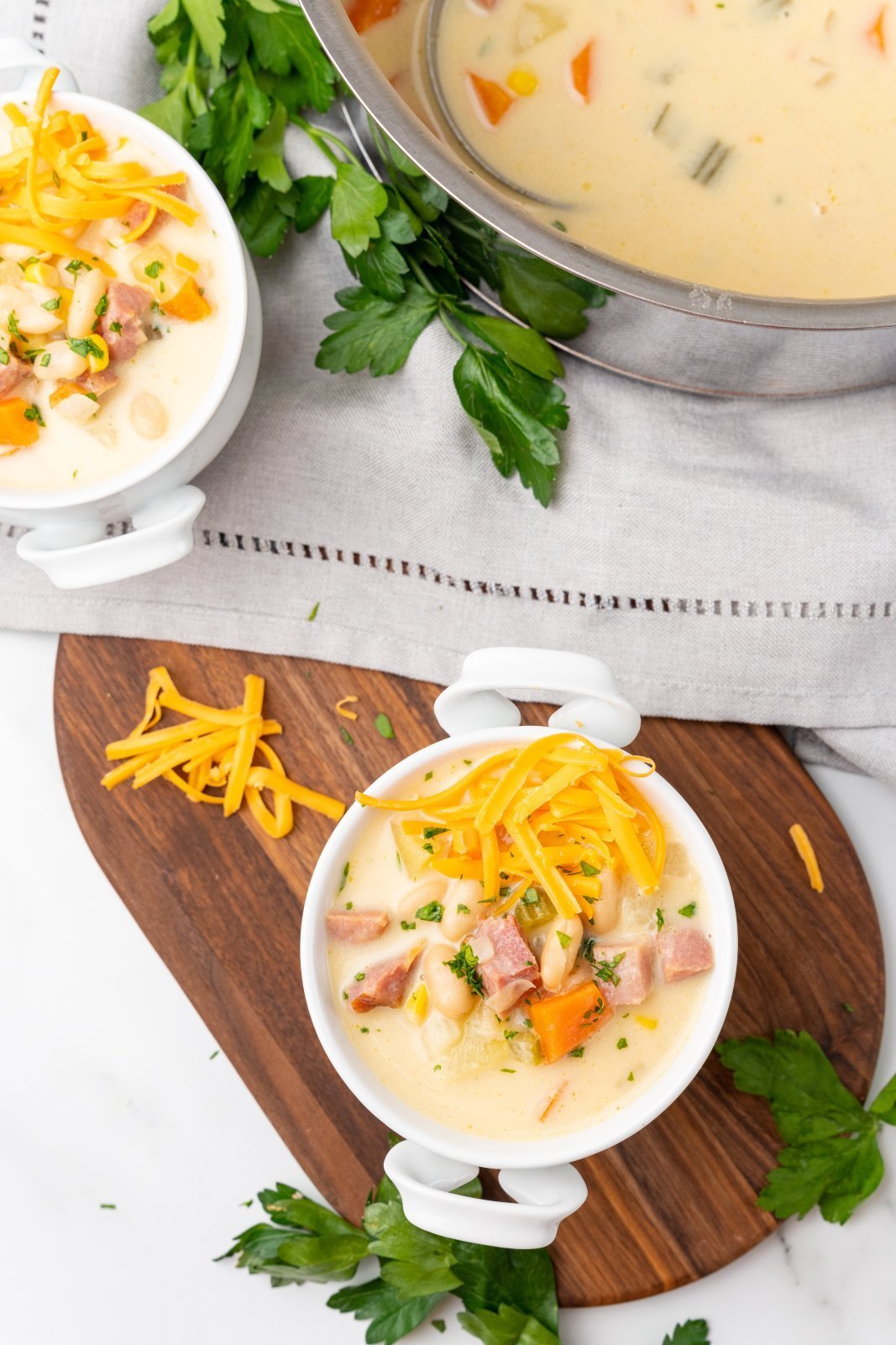 two bowls and a pot of creamy white bean soup