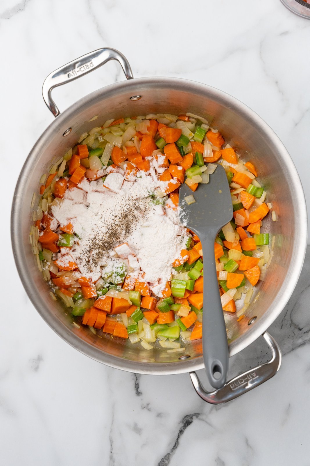 flour sprinkled on onion, carrot, and celery in a large stockpot