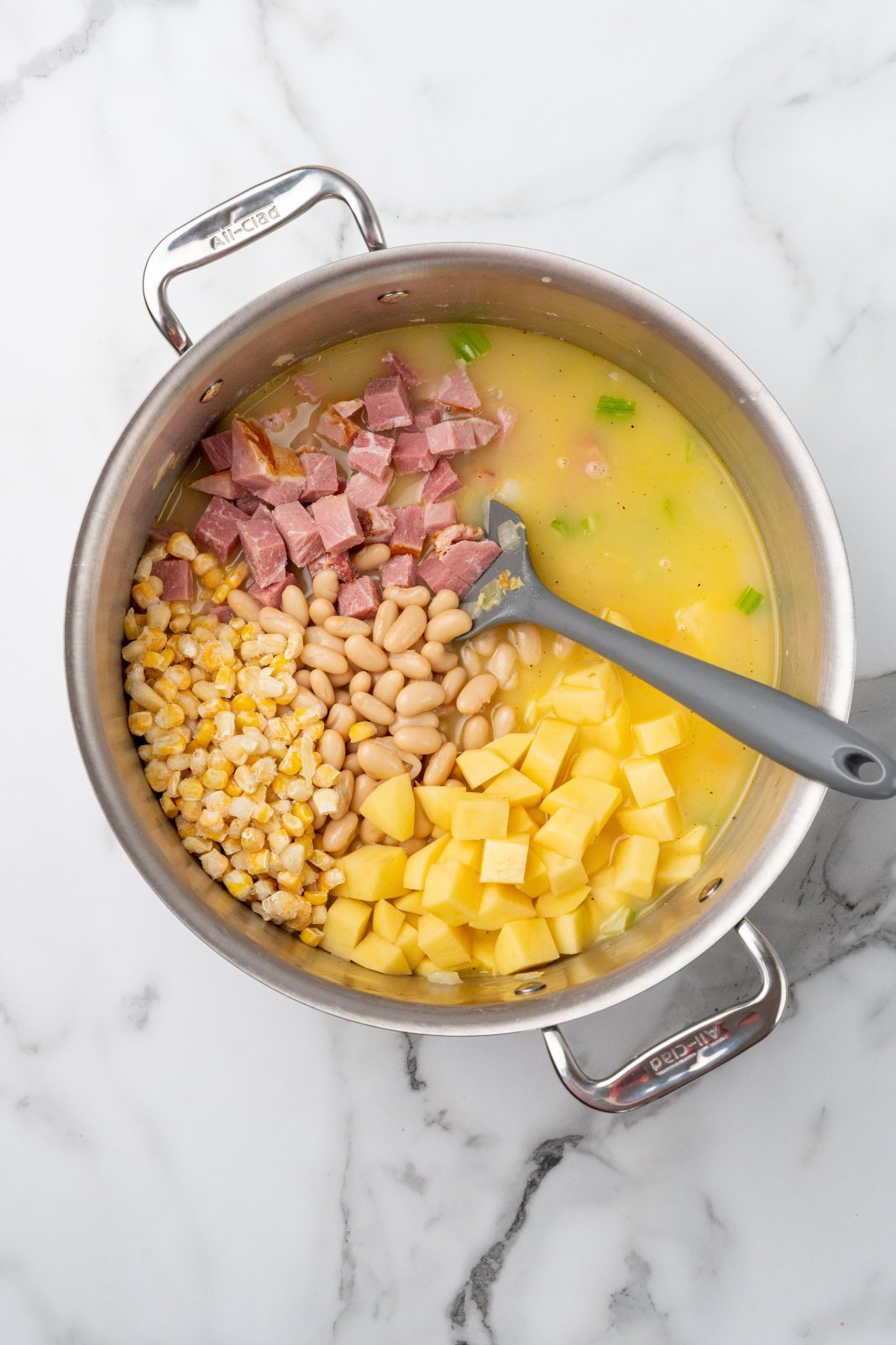corn, ham, beans, and potatoes added to the soup