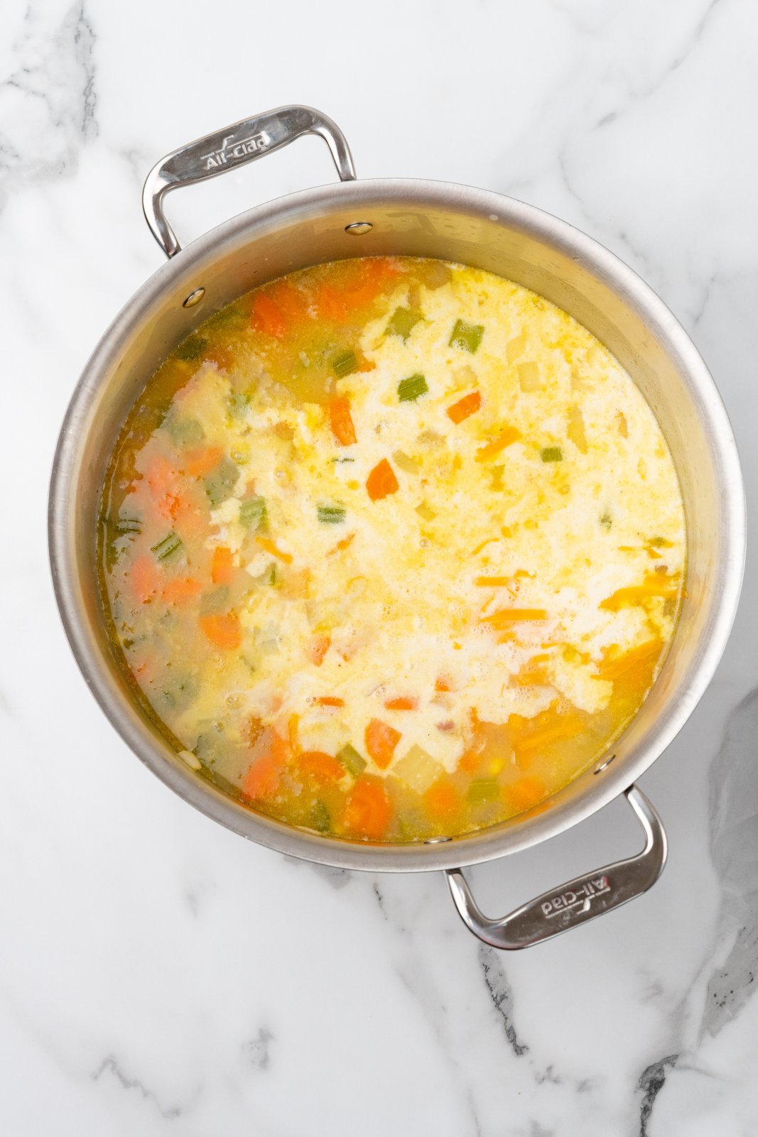 cream and cheese added to the pot of soup