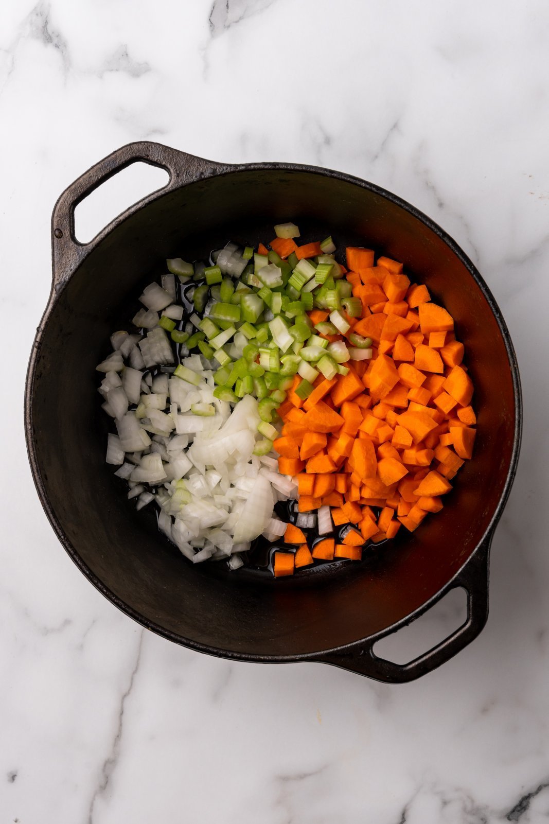 a view of raw onion, celery and carrot in the soup pot