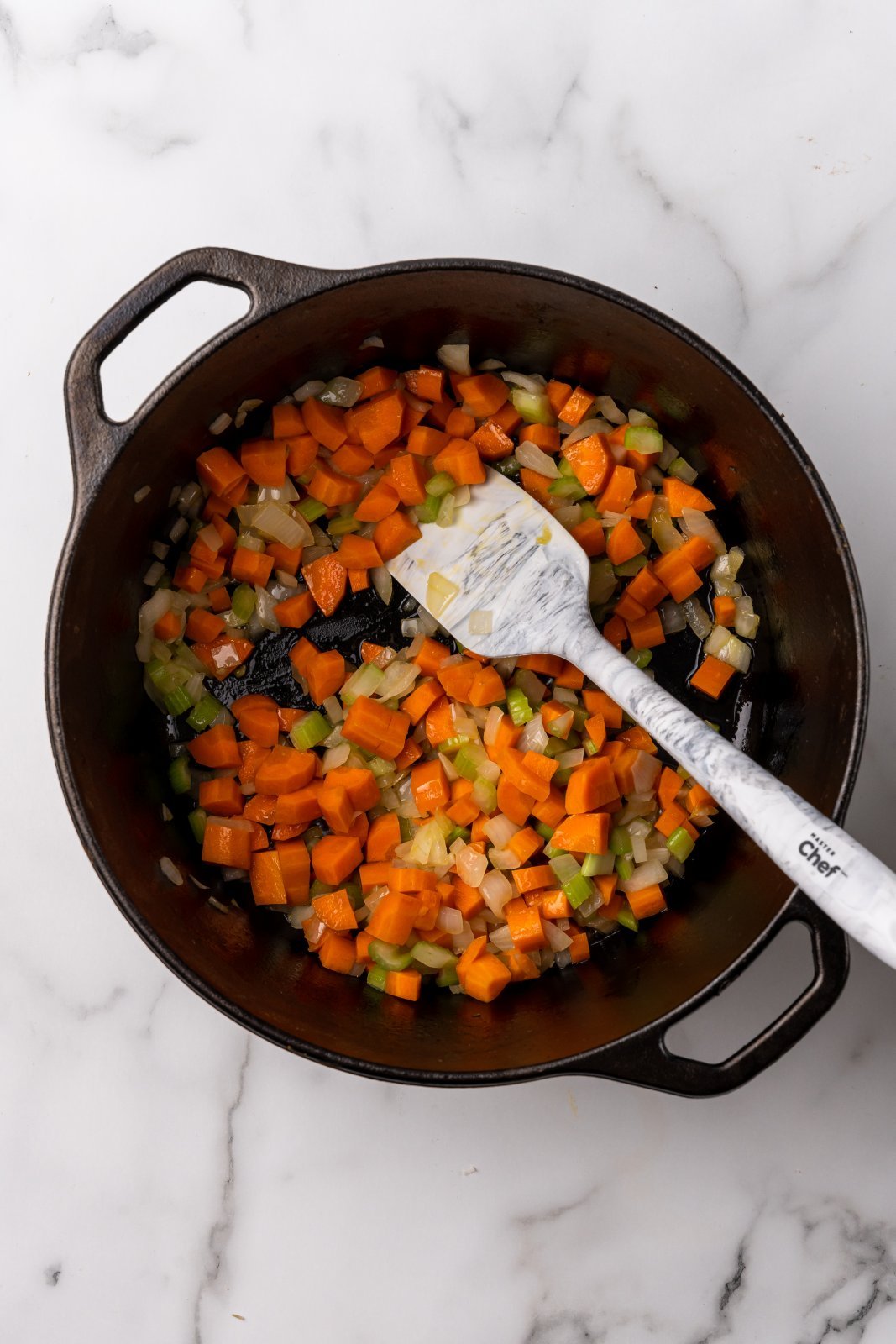 a view of cooked onion, celery and carrot in the soup pot
