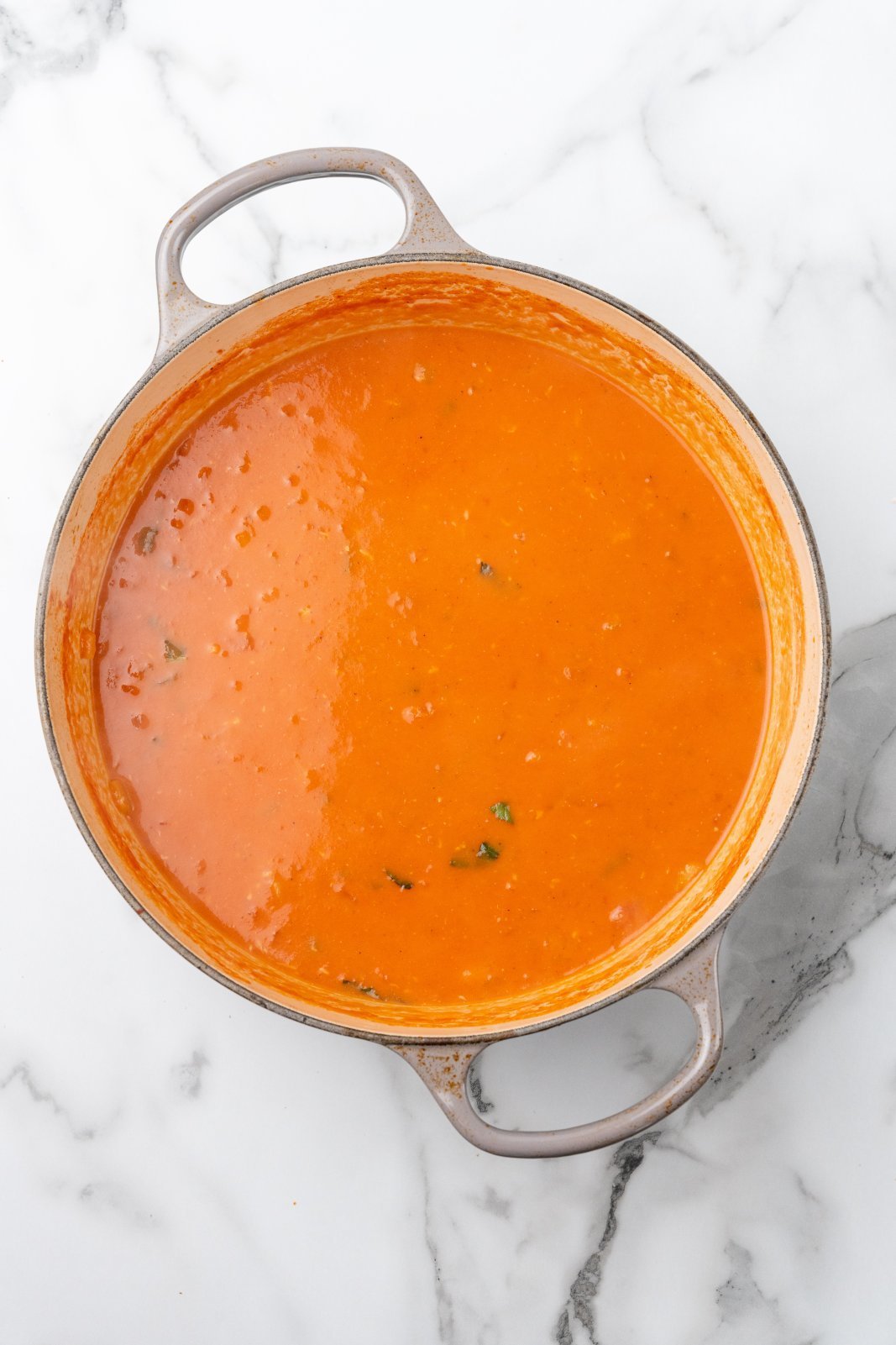 creamy tomato gnocchi soup finished in a large grey dutch oven
