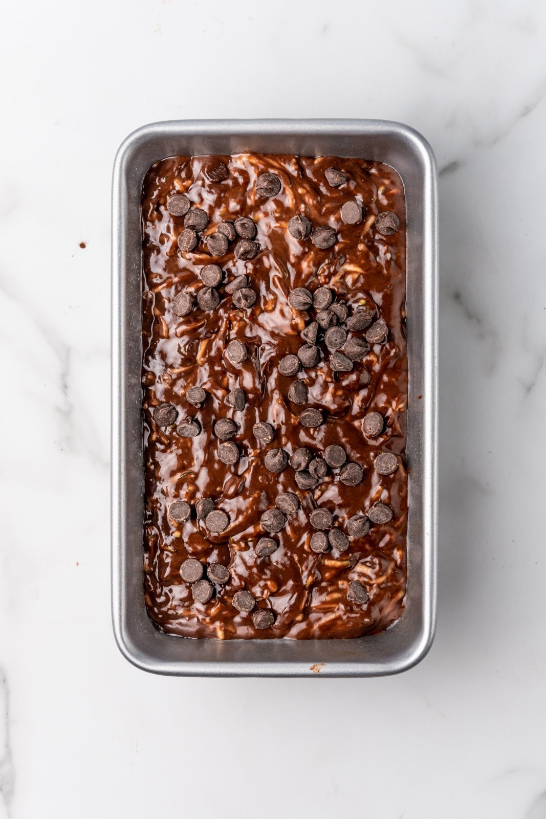 raw chocolate zucchini bread batter in loaf pan