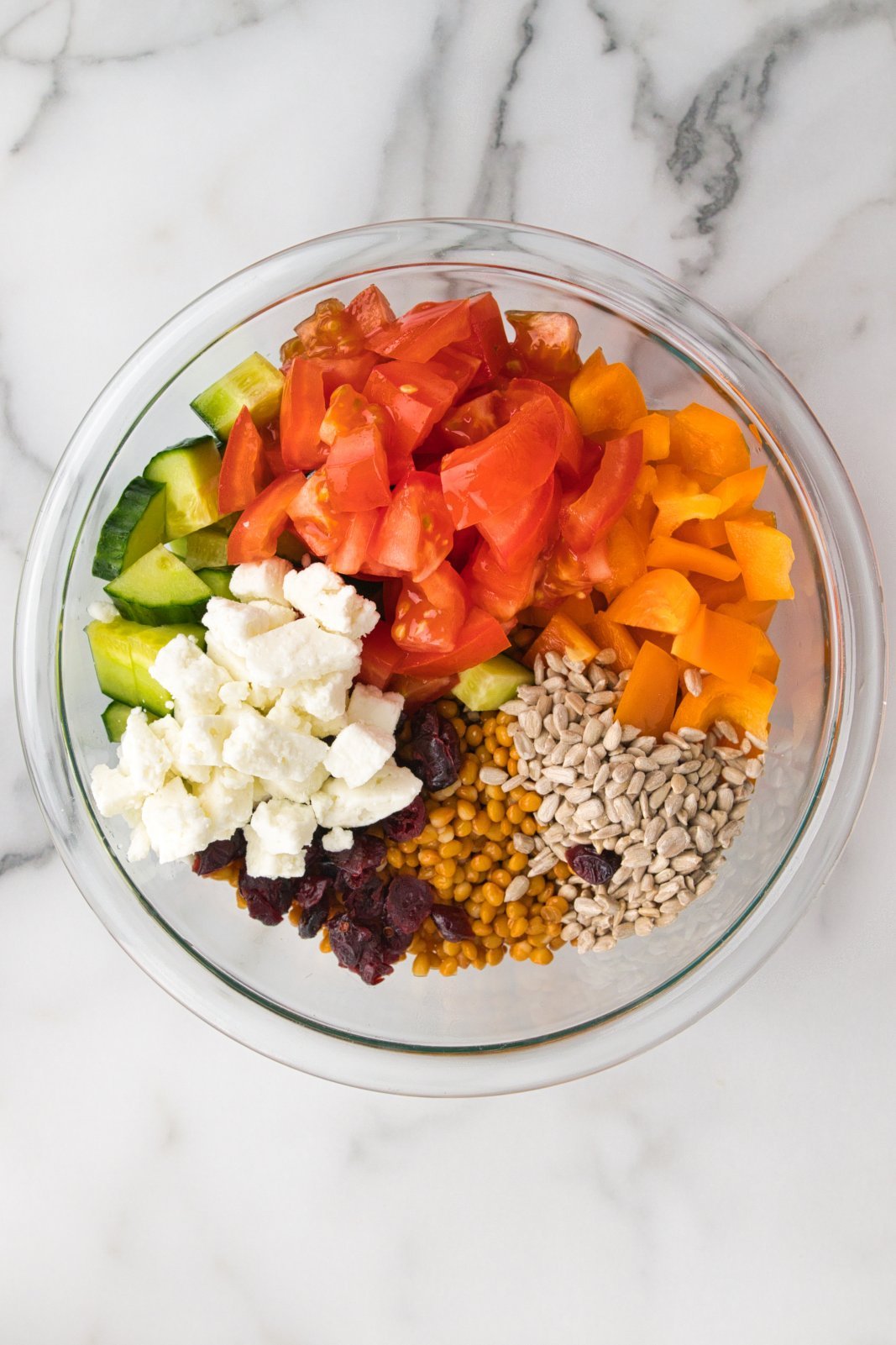 a bowl with the ingredients for lentil feta salad