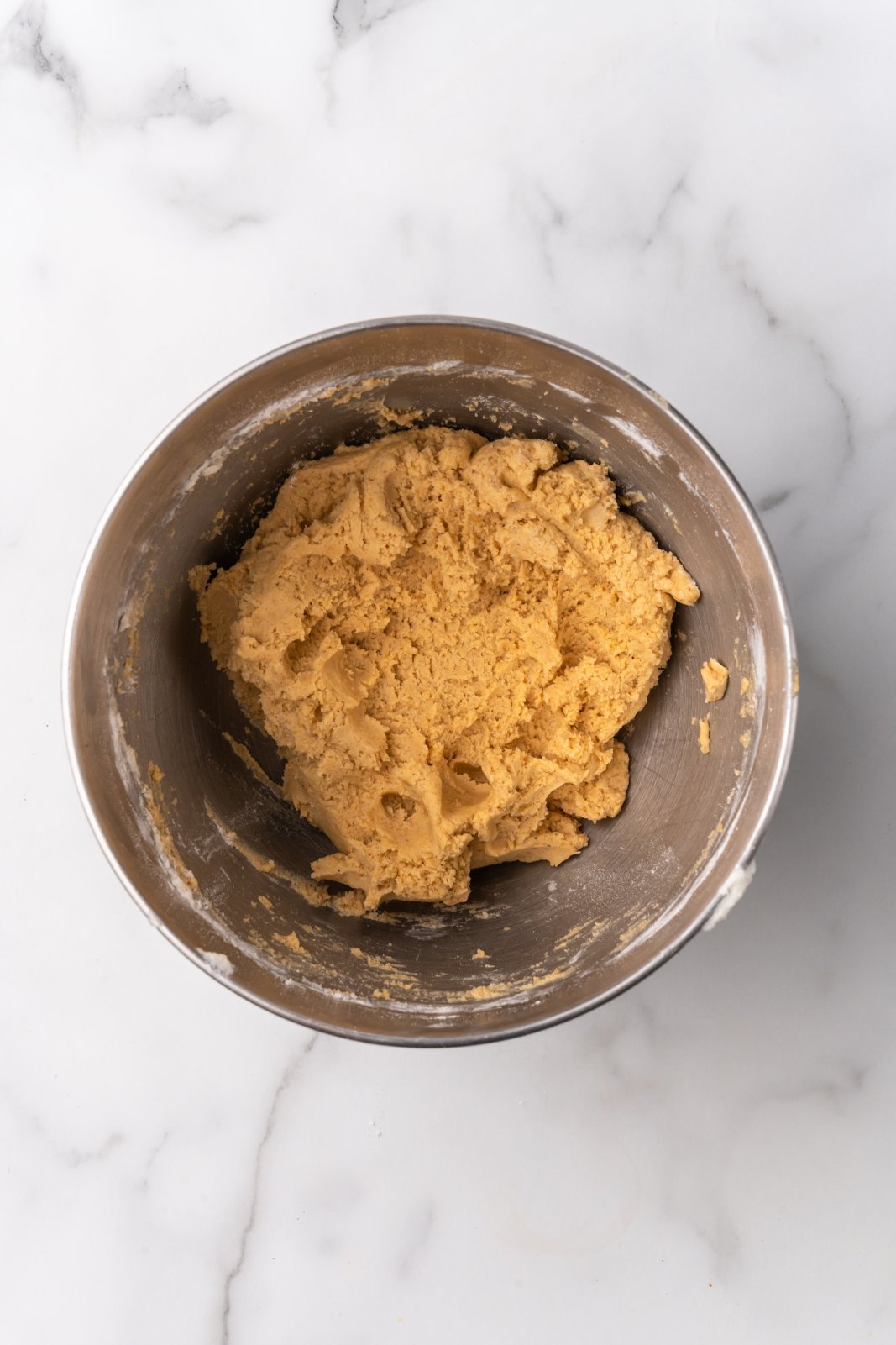 pumpkin sugar cookie dough  in stand mixer bowl