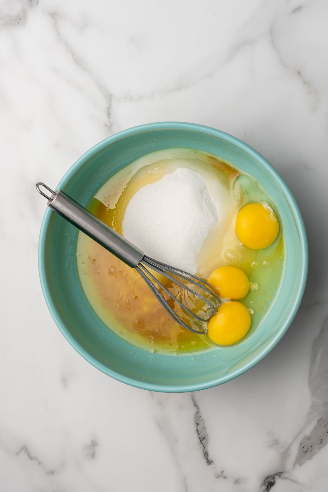 sugar, melted butter, eggs and vanilla in a bowl with a whisk on top