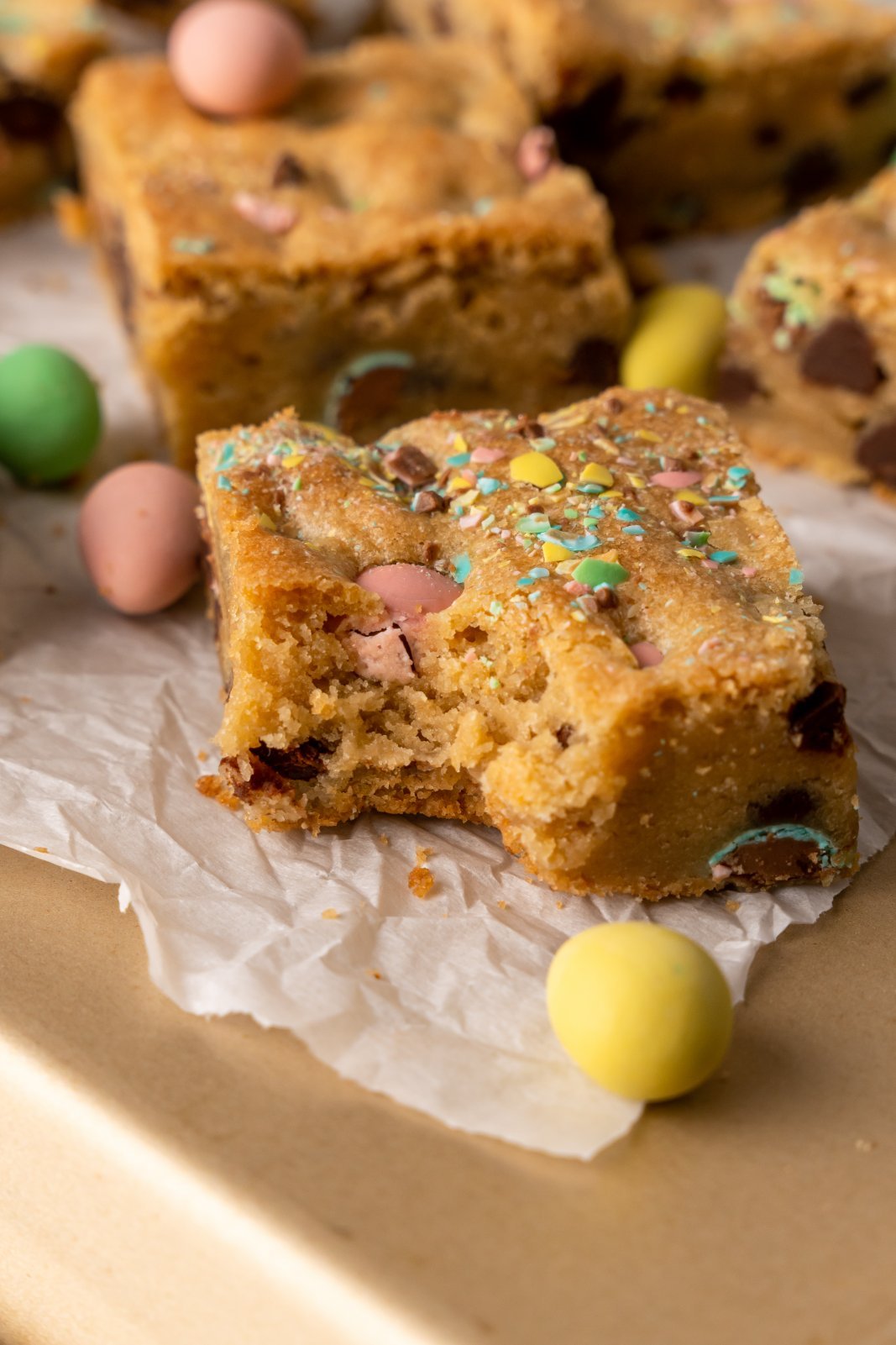 a close up of a mini egg cookie bar with a bite taken out of it