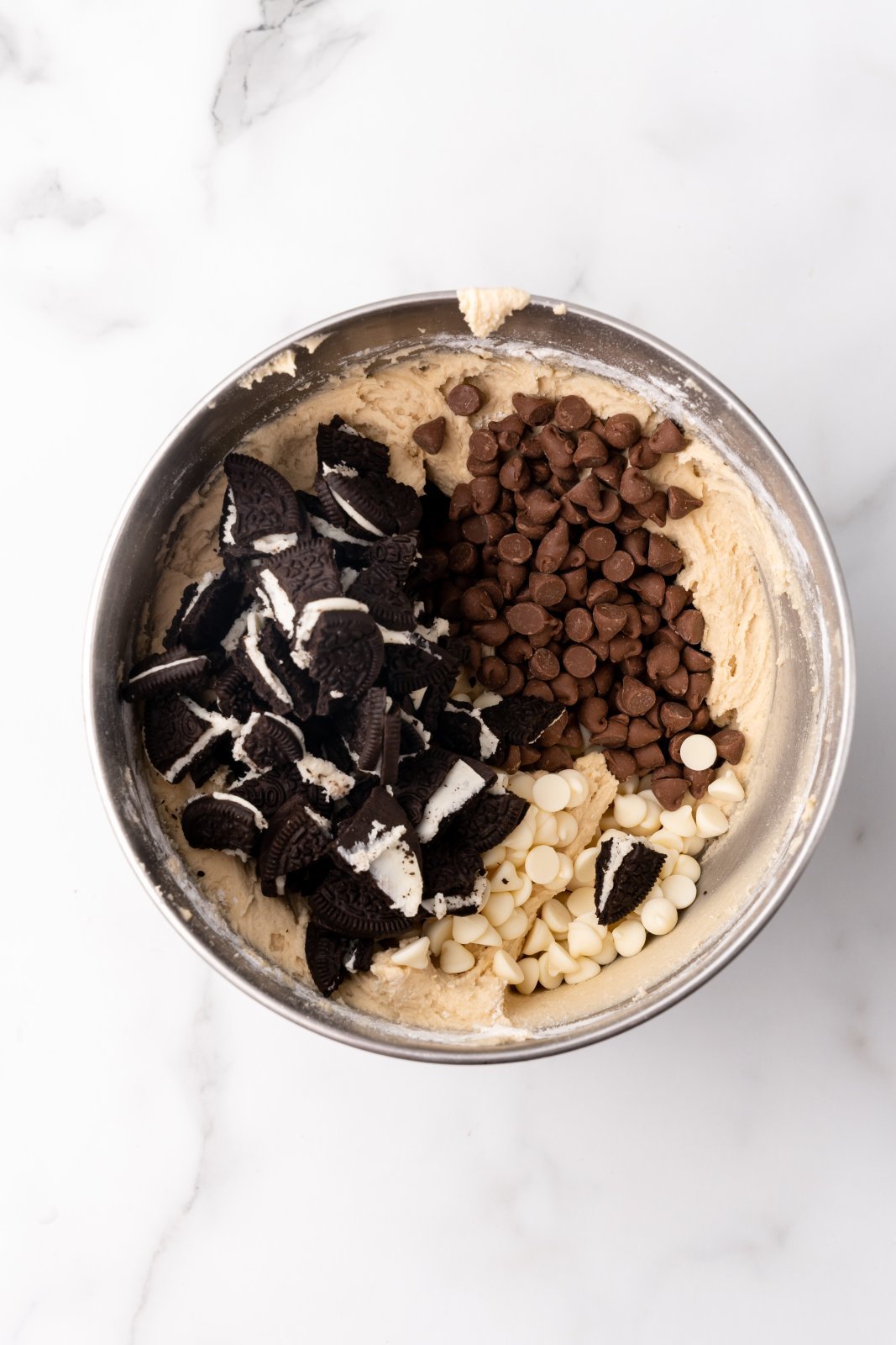 chocolate chips and cookie pieces added to bowl