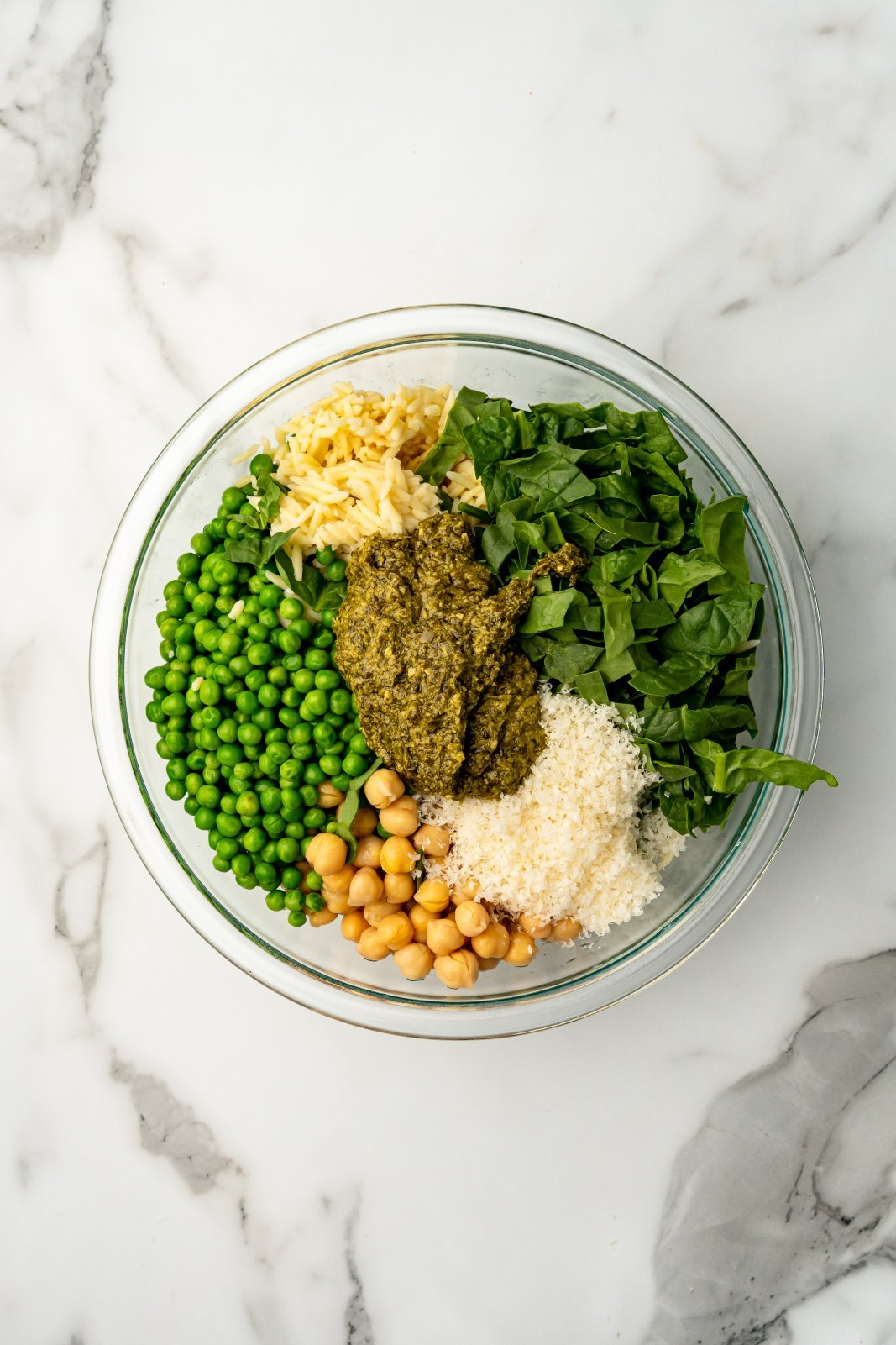 ingredients for orzo pesto salad in a large bowl before mixing
