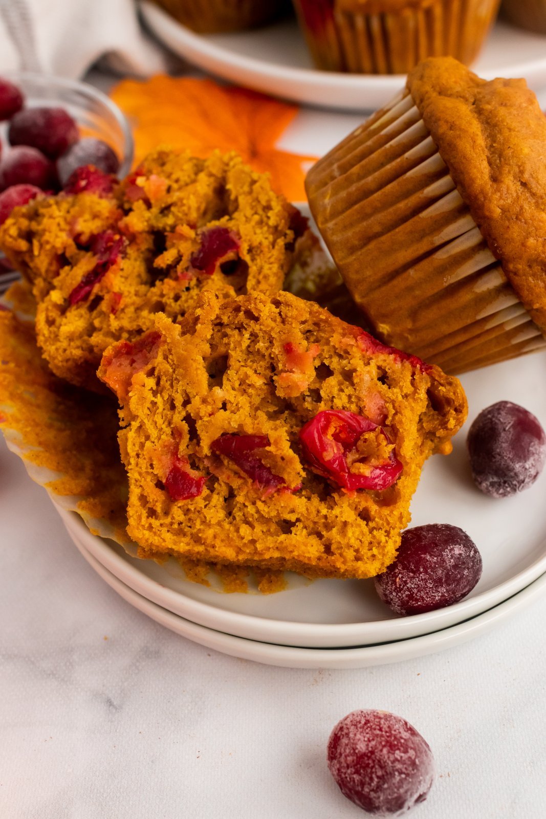 a muffin is cut in half to show the inside with some cranberries inside