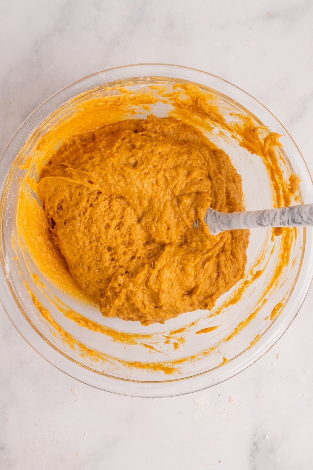 pumpkin muffin batter in a large mixing bowl is shown