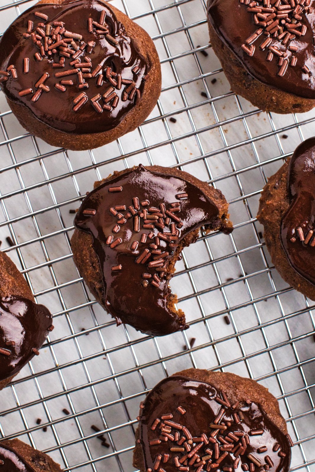 triple chocolate ricotta cookies on a cooling rack with the center one with a bite taken out