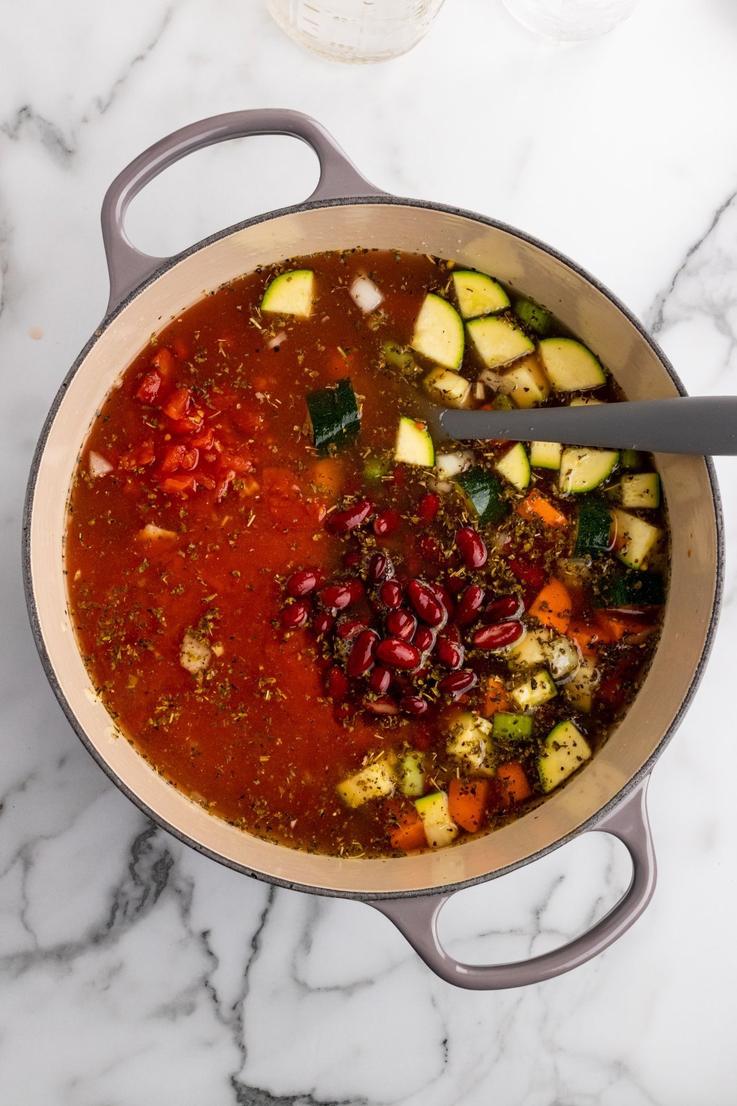 soup pot with veggies, seasoning, beans and broth added