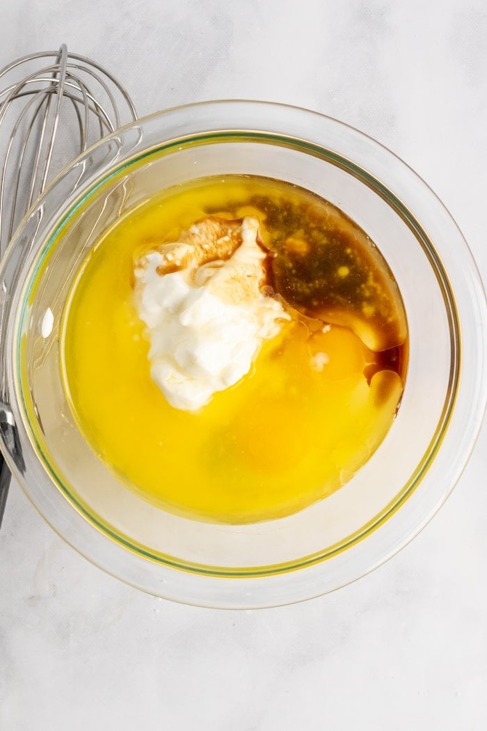 a bowl showing the wet ingredients needed for peach cobbler muffins